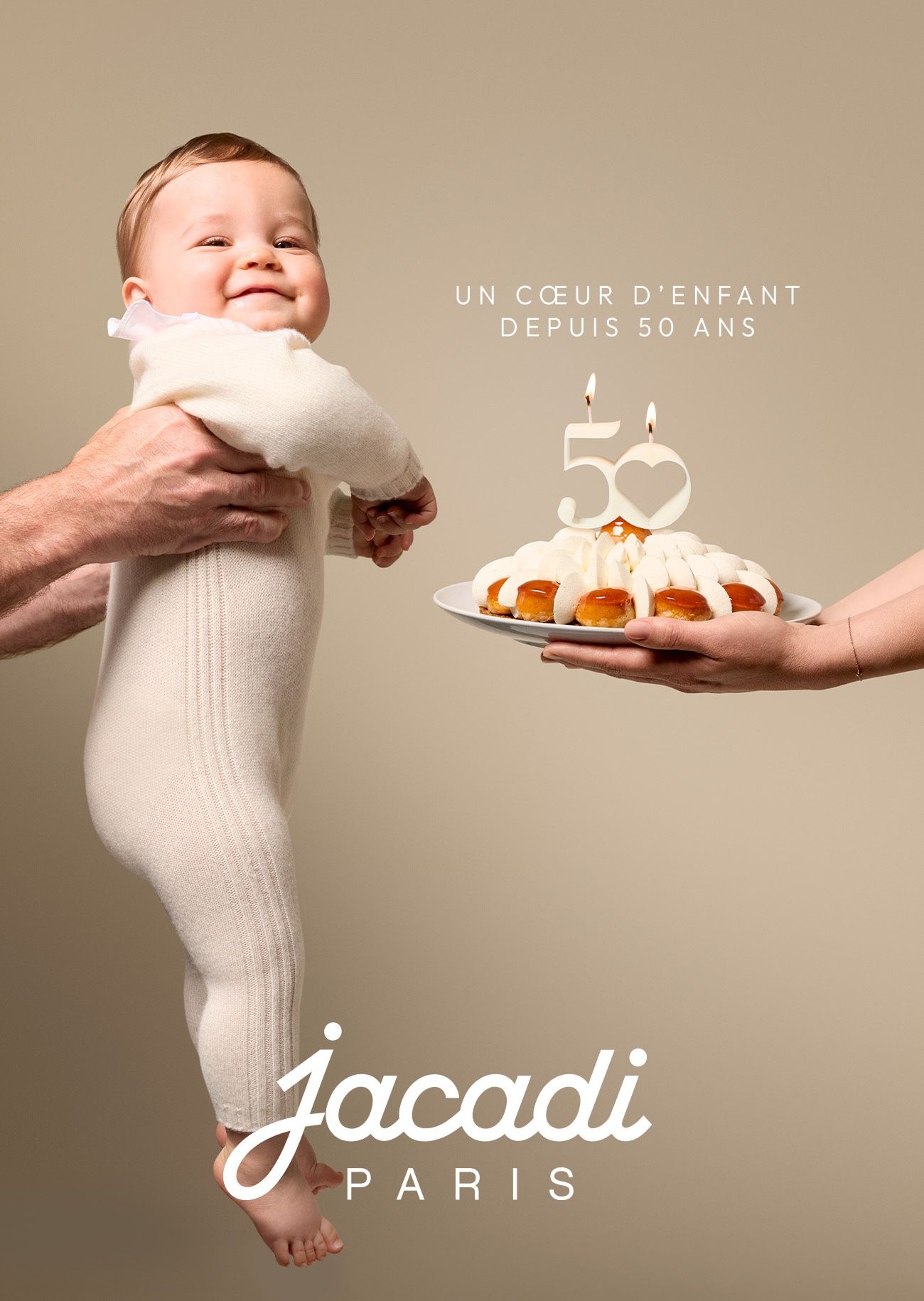 baby wearing a cashemer set ready to bloaw the 50 years cake candles for Jacadi